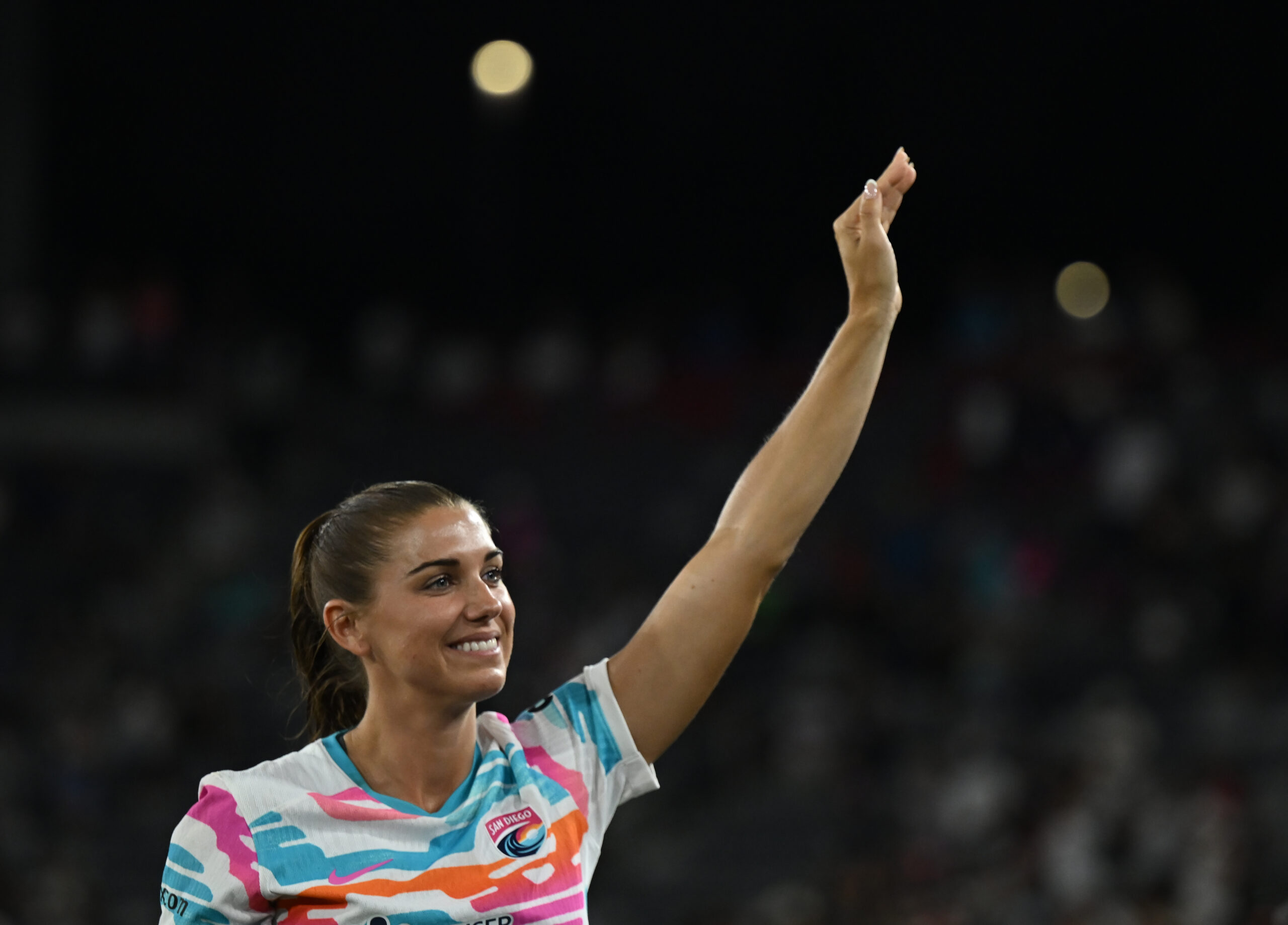 Alex Morgan waves to the crowd at her last game