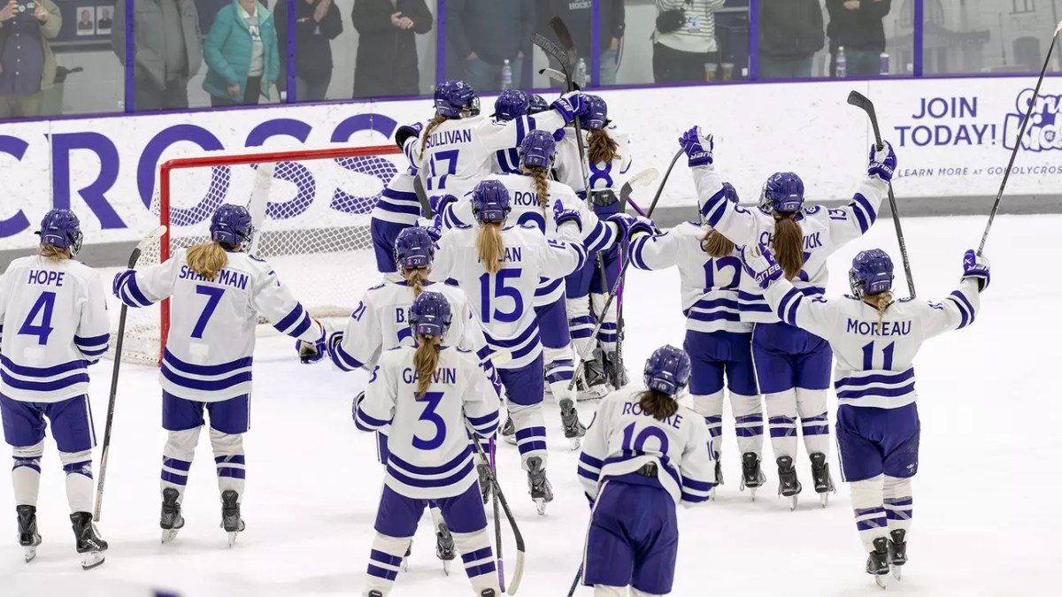 Holy Cross celebrates around Abby Hornung's net in the home arena.